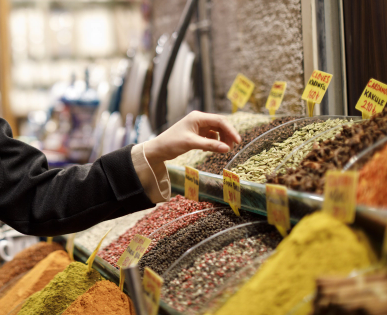 Woman selecting bulk herbs at a market